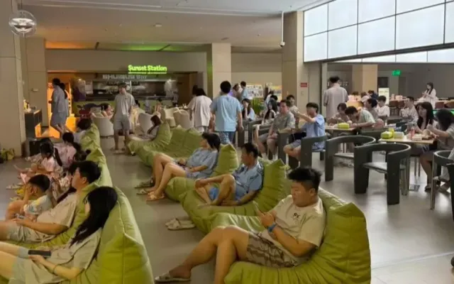 Guests in house pyjamas resting on green beanbag loungers in the dry-area lounge of Shuiguo bathhouse in Shanghai