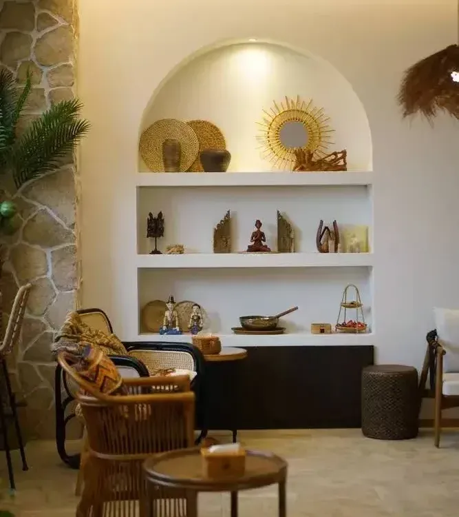 Rattan armchairs and carved wooden shelves of Balinese ornaments in the lounge of a Bali-style spa in Shanghai