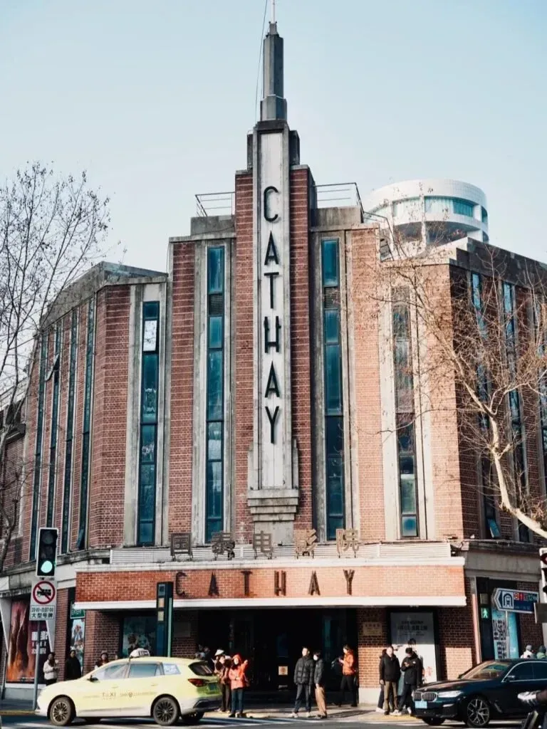 The Cathay Theatre on Huaihai Middle Road, a 1930s brick cinema with a vertical CATHAY sign above the entrance