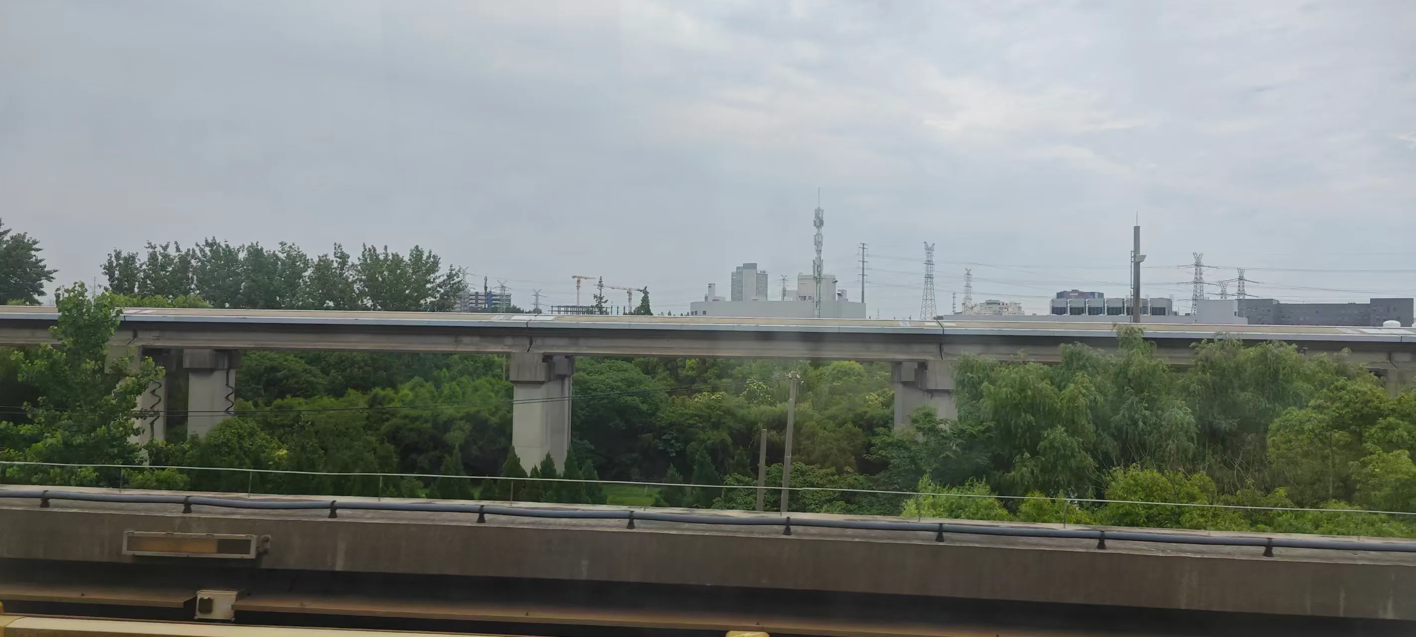 Elevated tracks and greenery seen through the window during a ride on the Shanghai Maglev
